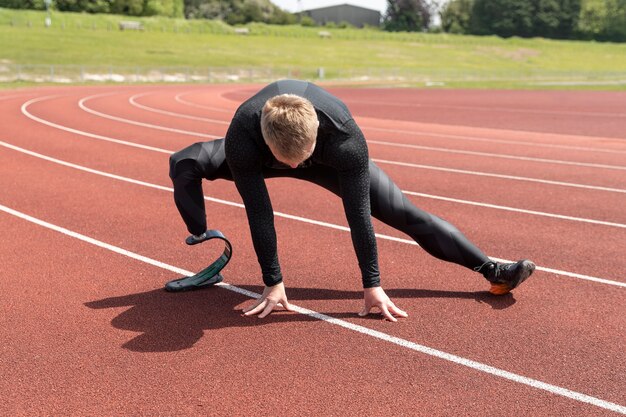 Full shot man with prosthetic leg stretching