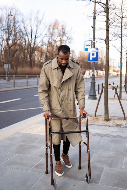 Free photo full shot man with walking frame in city