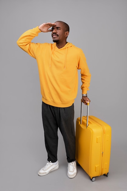 Free photo full shot man with yellow baggage