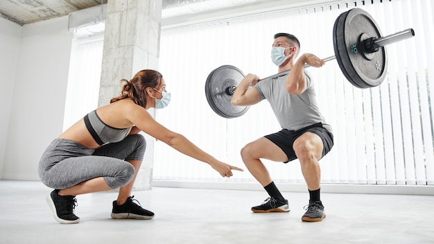 Free photo full shot man and woman training with masks