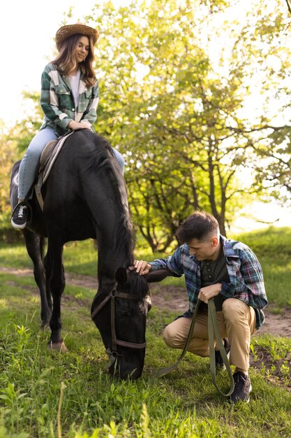 Full shot man and woman with horse
