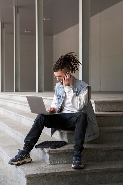 Full shot man working on laptop outdoors