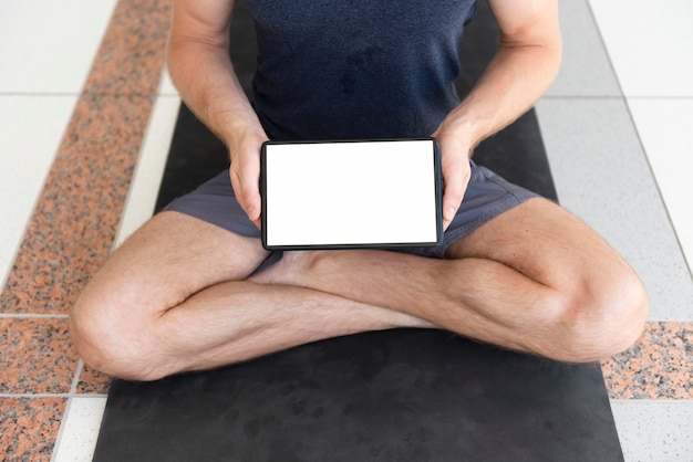 Full shot man on yoga mat with blank tablet