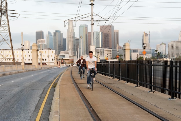 Foto gratuita uomini del colpo pieno che guidano le biciclette