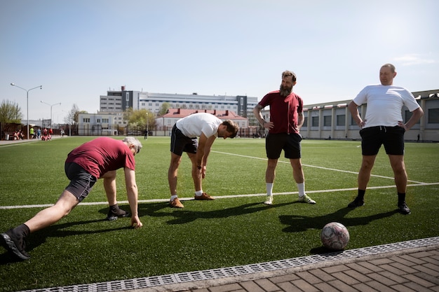 Foto gratuita uomini a tutto campo che si allungano prima della partita