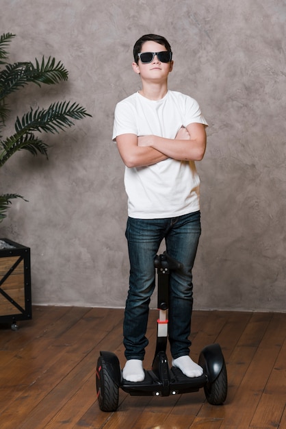 Free photo full shot of modern boy with sunglasses on hoverboard