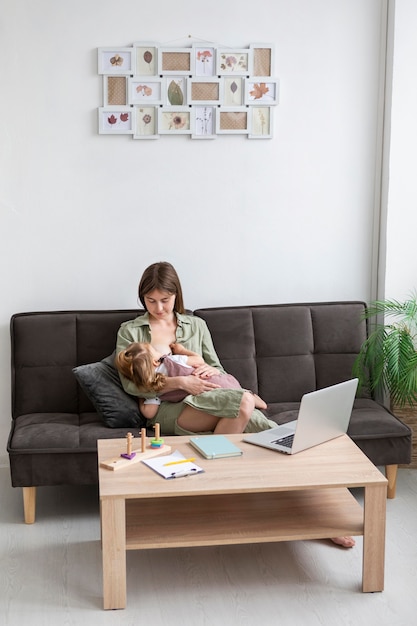 Full shot mother breastfeeding girl