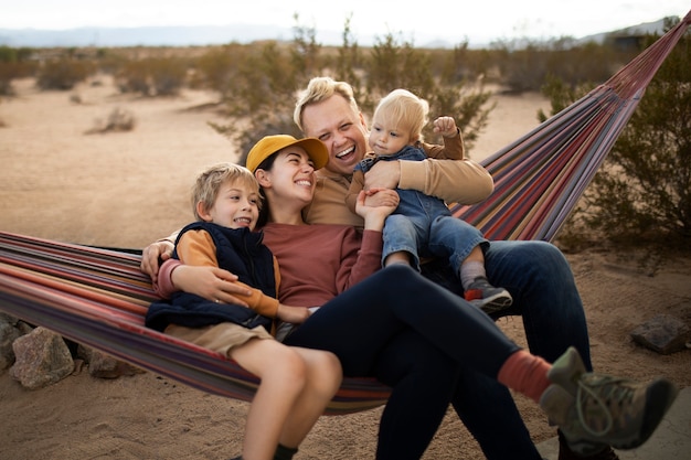 Free photo full shot mother and children on hammock