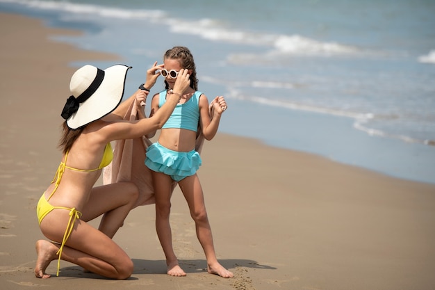 Полный снимок матери и девушки на пляже