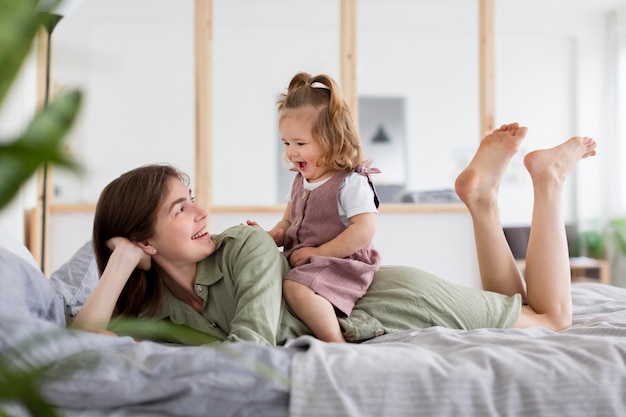 Free photo full shot mother and girl in bed