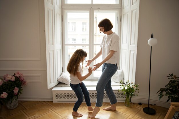 一緒に踊るフルショットの母と少女