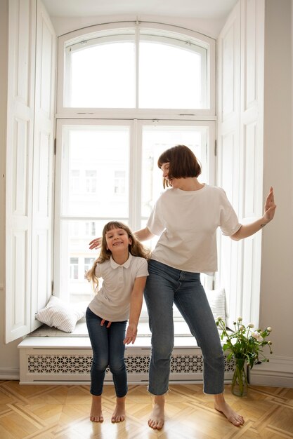 Full shot mother and girl dancing