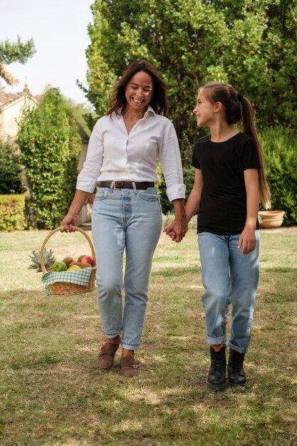 full shot mother and girl holding hands