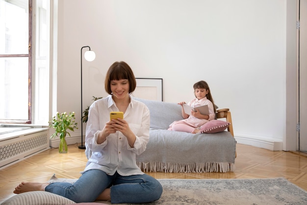 Full shot mother and girl in livingroom