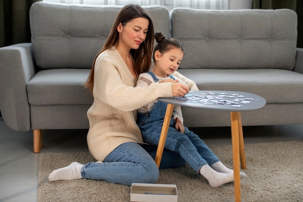 Free photo full shot mother and girl playing game