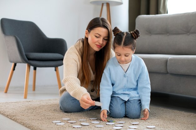 Full shot mother and girl playing game