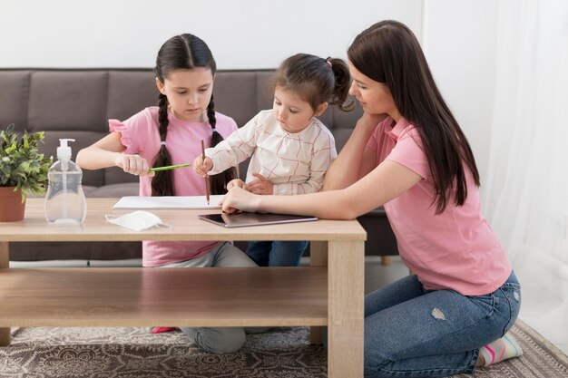 full shot mother and girls at table