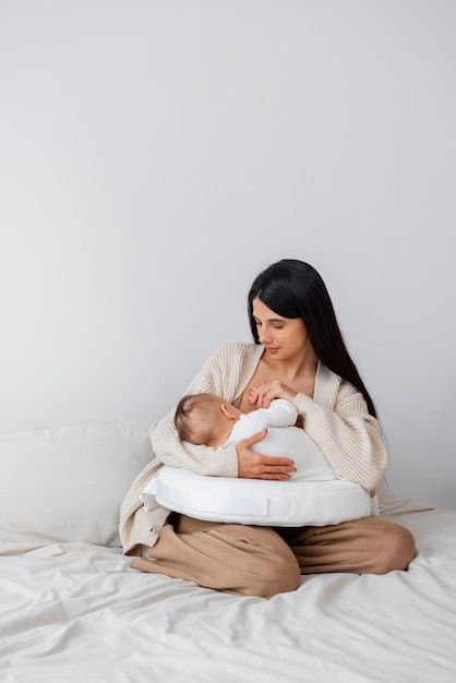 Full shot mother holding newborn baby