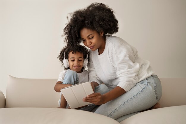 Full shot mother holding tablet