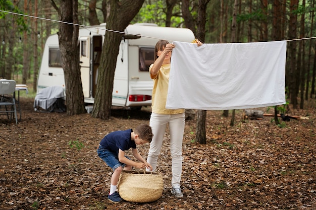 Full shot mother and kid doing chores in forest