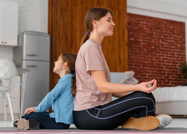 Full shot mother and kid meditating