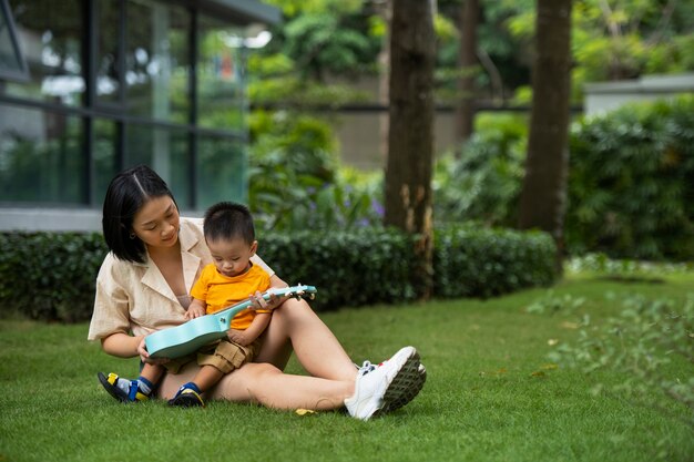 草の上に座っているフルショットの母親と子供