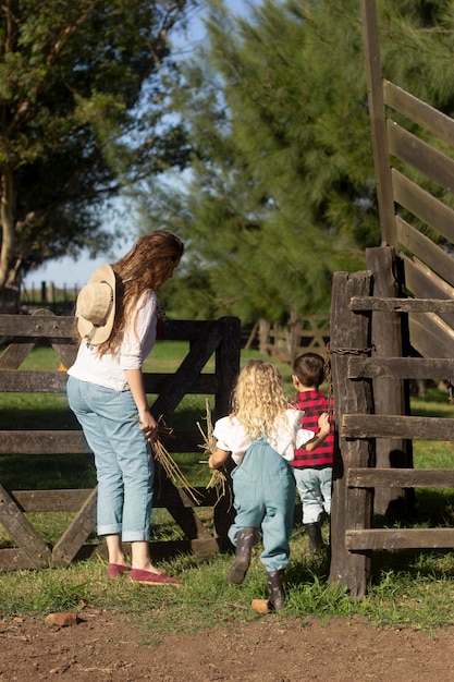 Full shot mother and kids at farm