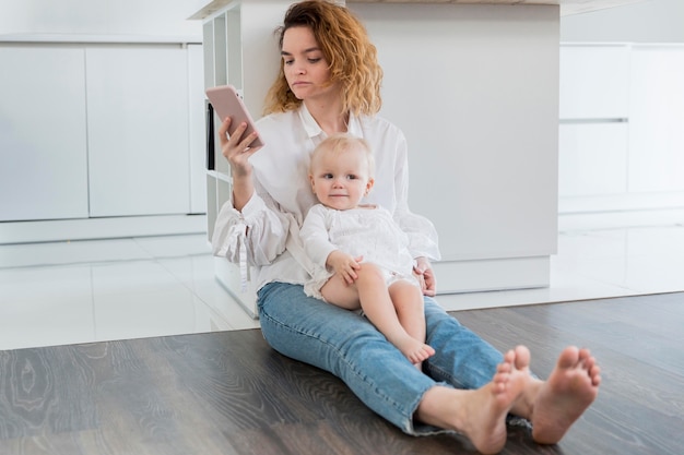 Full shot mother sitting on floor