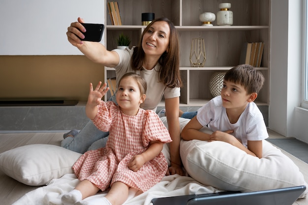 Foto gratuita madre a tutto campo che si fa selfie con i bambini