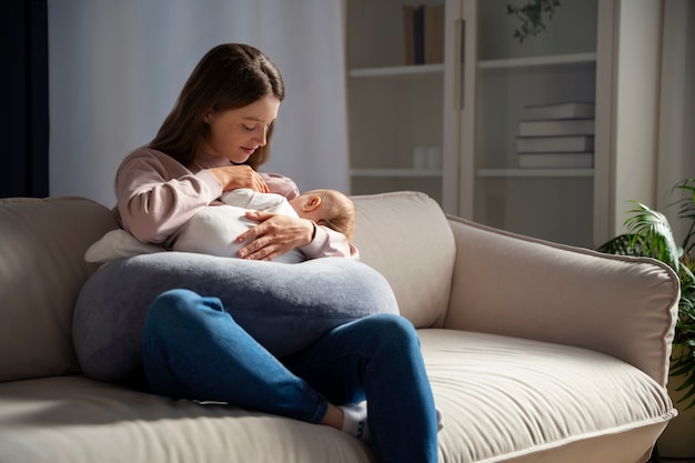 Full shot mother with cute newborn