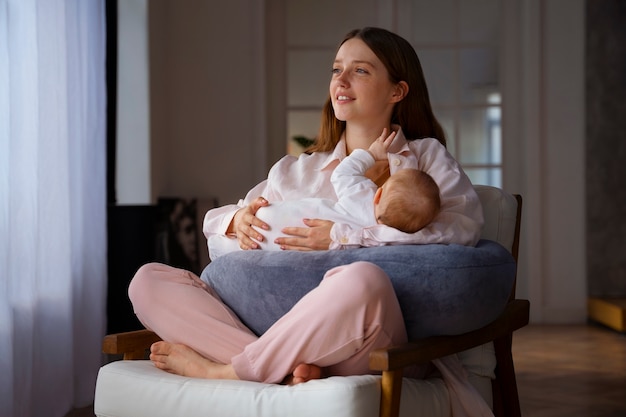 Free photo full shot mother with cute newborn