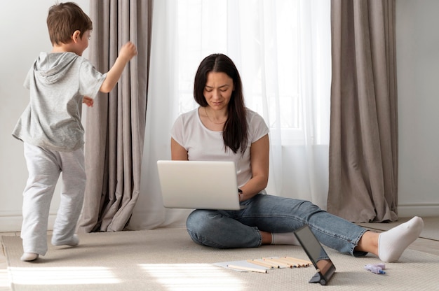 Full shot mother working remotely