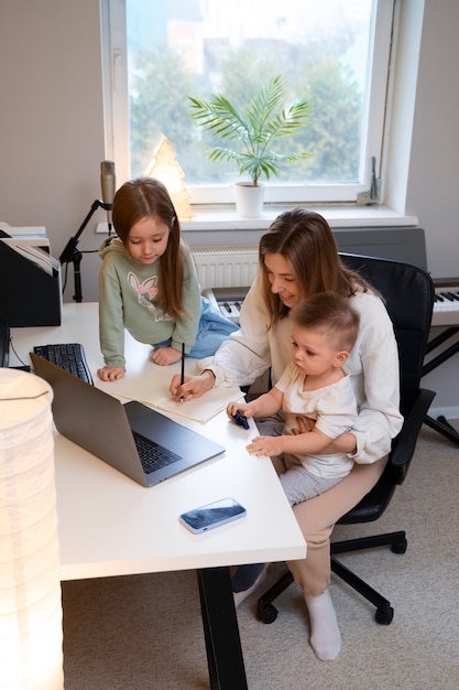 Free photo full shot mother working remotely