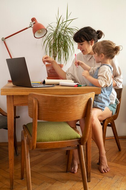 Full shot mother working with girl