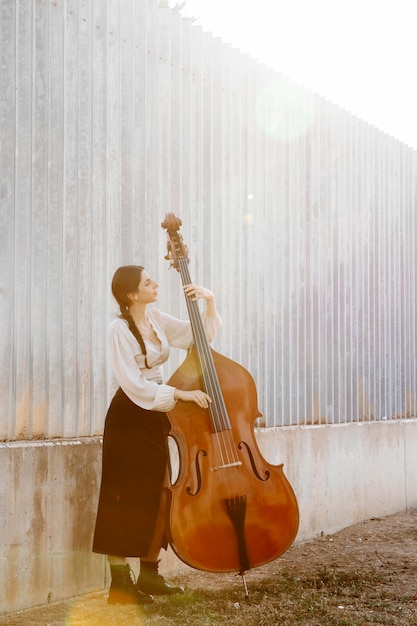 Free photo full shot musician holding instrument