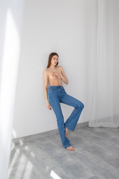 Full shot nude woman posing in jeans