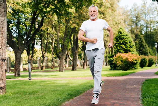 Full shot old man running outdoors