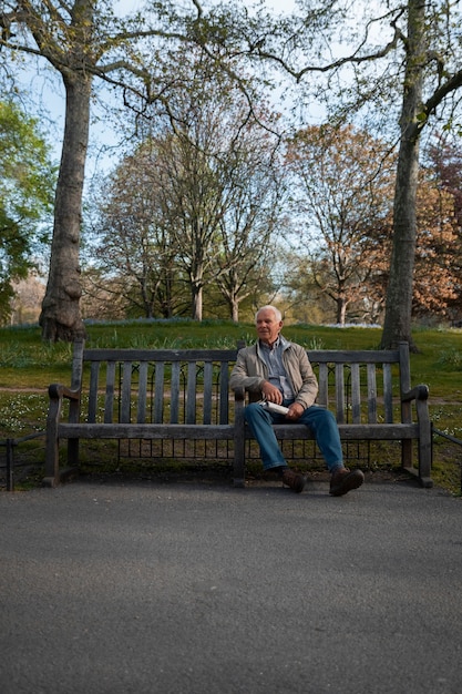 Free photo full shot old man sitting on bench