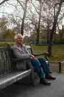 Free photo full shot old man sitting on bench