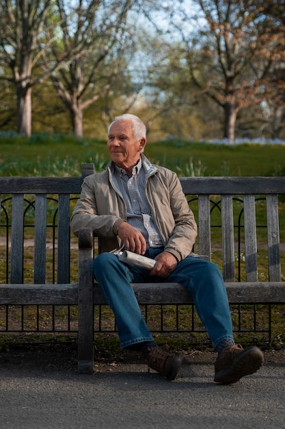無料写真 ベンチに座っているフルショットの老人