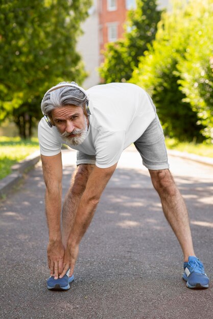 Full shot old man stretching outdoors