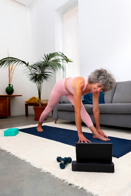 Free photo full shot old woman exercising at home