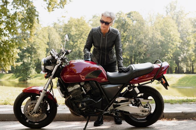 Full shot old woman with cool motorcycle