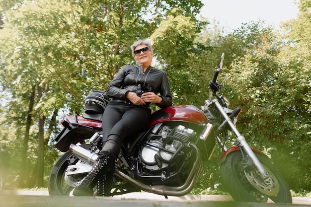 Free photo full shot old woman with cool motorcycle