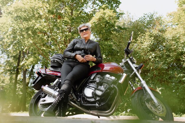 Full shot old woman with cool motorcycle