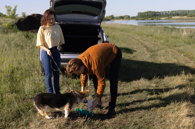 Proprietari a tutto campo che danno acqua al cane