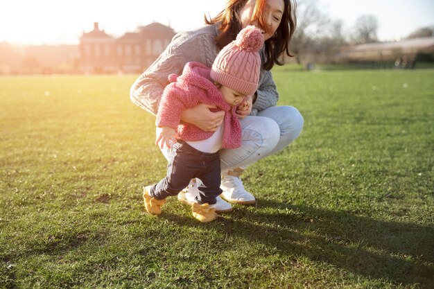 Full shot parent and baby walking together in nature