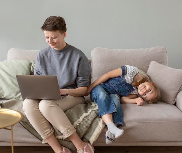 Foto gratuita genitore e bambino del colpo pieno sul divano