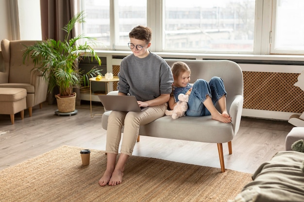 Full shot parent and kid on couch