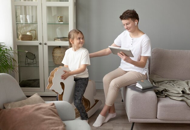 Full shot parent with tablet at home